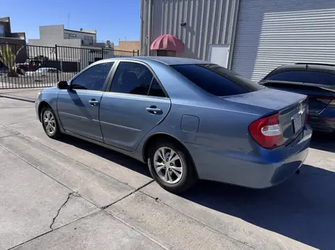 2004 Toyota Camry window tint: Wrapped up in our 15% C-IR on sides and rear window and a 5% Sunstrip before they get a full color change wrap done (view 3)