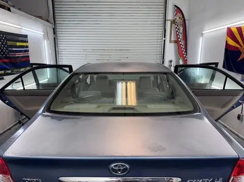 2004 Toyota Camry window tint: Wrapped up in our 15% C-IR on sides and rear window and a 5% Sunstrip before they get a full color change wrap done (view 5)
