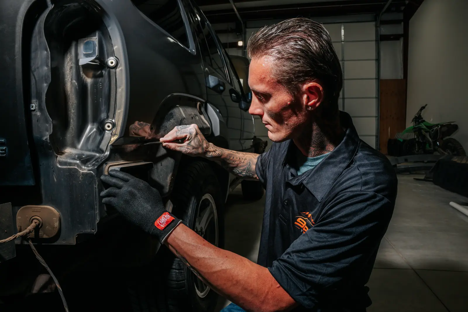 Jonny finishing a film edge along a Jeep door